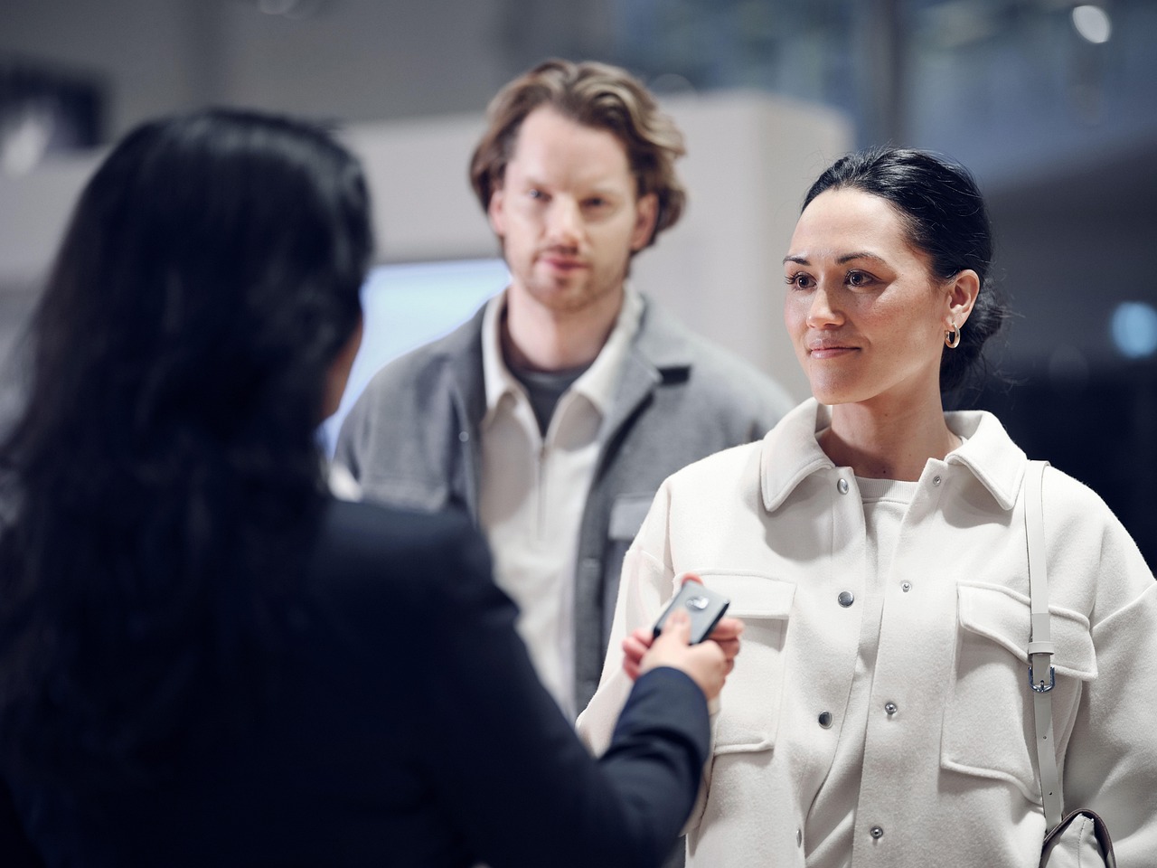 Car dealership salesperson handing over keys to a happy customer