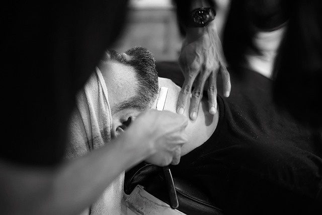 Barber giving a straight-razor shave to a customer in a small barbershop