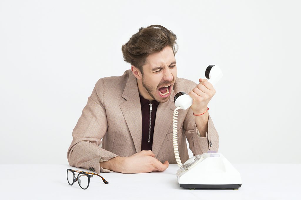 frustrated man yelling into phone 